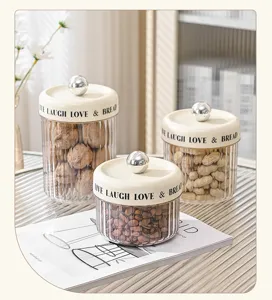 Set of ribbed clear plastic storage jars with cream lids and silver knobs for kitchen