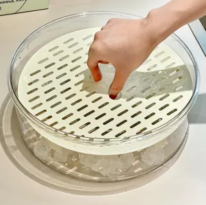 Detail of the perforated drain tray and ice cooling base in the clear storage box.