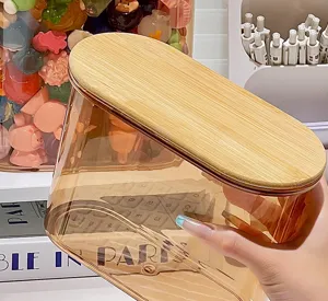 Detaillierte Makroansicht eines bernsteinfarbenen Acryl-Vorratsglases mit Bambusdeckel.