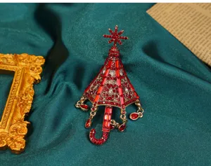 Detailaufnahme einer Vintage-Regenschirm-Brosche mit roten Strasssteinen auf Seide
