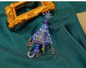 Makroansicht einer Vintage-Schirmbrosche mit blauen Kristallen und Schneeflocke