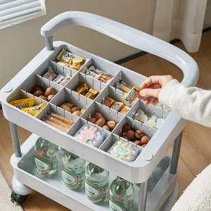 Multi-tier white plastic rolling utility cart organized with various snacks and drinks