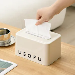 Caja de pañuelos de color crema con muelle en escritorio de madera