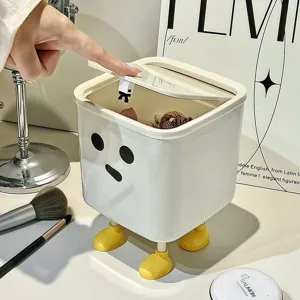 Detail view of cute white cartoon desktop bin with yellow feet and lid being opened by hand