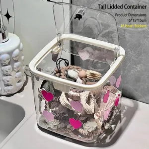 Detail view of a transparent desktop storage box with pink heart stickers and lid.