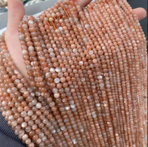 Dettaglio di perle rotonde di cristallo occhio di gatto arancione naturale per gioielli fai da te.
