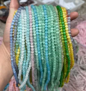 Dettaglio di varie perle tonde colorate in pietra occhio di gatto per gioielli fai da te.