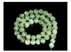 Détail macro de perles rondes en préhnite verte naturelle pour la création de bijoux