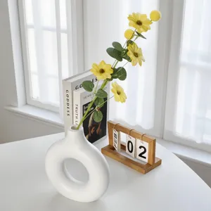 Fleur de cosmos jaune artificielle dans un vase en céramique blanc pour décoration