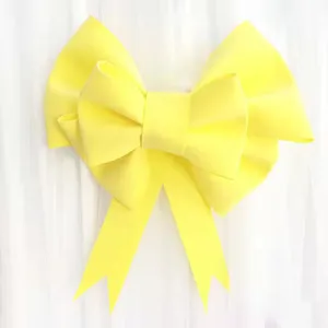 Large yellow decorative bow pendant for Christmas tree and festival party wall decor.
