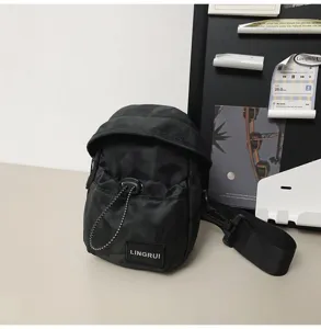 Detailed view of the black camouflage pattern and LINGRUI brand label on this outdoor chest bag