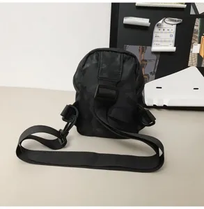 Detail of black camouflage crossbody bag with adjustable strap for urban outdoor use.
