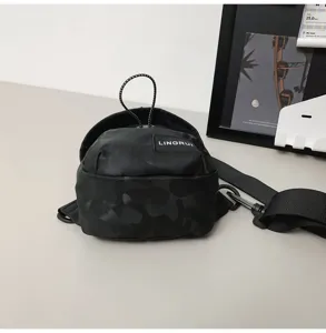 Close-up of the trendy black camouflage chest bag featuring a branded fabric label