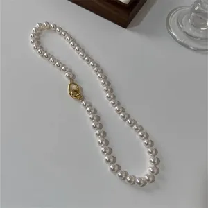 Detailopname van een elegante witte parelketting met een gouden sluiting