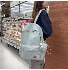 Detailansicht eines hellblauen süßen Rucksacks mit großem Fassungsvermögen am Modell.