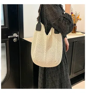 Gedetailleerd opname van een chique beige gehaakte shopper met zwarte lederen bandjes dames.