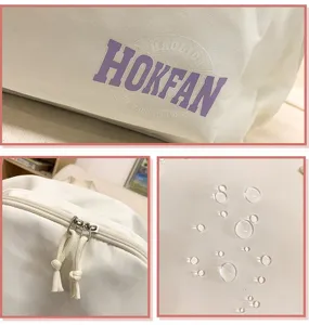 Detaillierte Nahaufnahme des weißen wasserdichten Rucksacks mit Logo und Reißverschluss