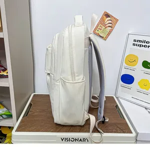 Side view detail of beige canvas backpack with multi-layer zippers and side pockets.