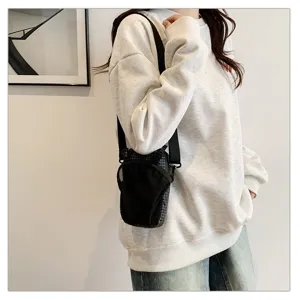 Detail view of the functional black outdoor waterproof crossbody phone bag on model