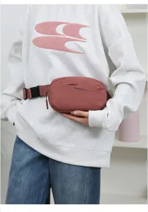 Stylish pink minimalist waist bag worn with a casual sweatshirt, showing product detail.