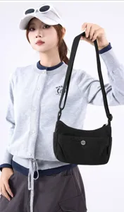 Stylish black nylon crossbody bag for women featured in a casual outdoor outfit look