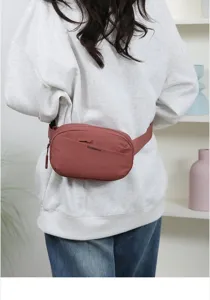Macro view of minimalist pink waist bag with Confidence print worn over casual sweatshirt
