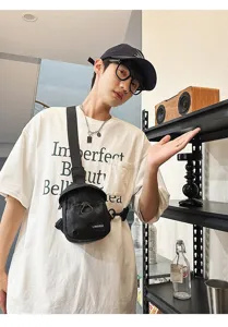 Close-up of a stylish black nylon chest bag being worn by a model in a trendy indoor setting
