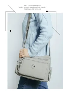 Detail view of the grey nylon multi-layer shoulder bag, featuring zipper pockets and strap.