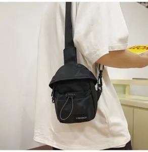 Close-up of black nylon chest bag worn with white t-shirt for outdoor leisure style