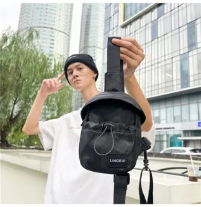 Black unisex trendy chest bag shown in an urban street style outdoor fashion view