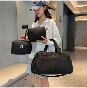 Bolso de viaje acolchado de nailon negro con neceseres, gran capacidad y diseño ligero.