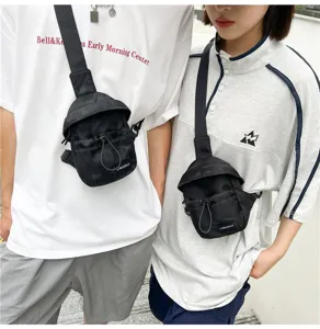 Detailed view of trendy black unisex chest bags worn by models for outdoor casual use