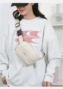 Detail showing the beige fanny pack worn over a white sweatshirt in a bright room.