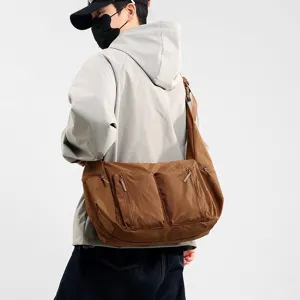 Brown nylon crossbody messenger bag detail, featuring dual front zip pockets and spacious design.