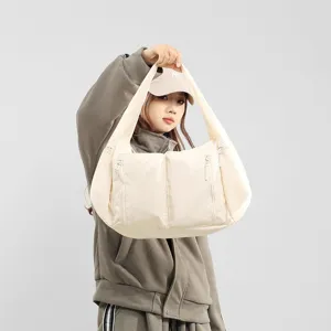 Detailed view of the large capacity beige hobo shoulder bag with convenient zipper pockets.