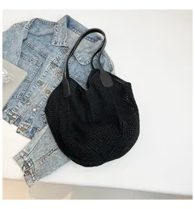 Detailopname van de zwarte gebreide katoenen tote bag, casual tas voor strand en vakantie.