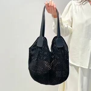 Detailfoto van de zwarte gebreide strandtas in retro stijl, ideaal voor de zomer.