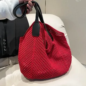 Detailopname van de rode gehaakte gebreide tas die het fijne unieke textuurpatroon toont.