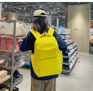 Casual bright yellow backpack lifestyle detail shot in store showcasing multiple pockets.