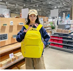 Detail view of casual yellow student backpack with multiple pockets in store scene.