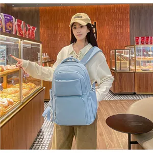 Detailed view of light blue casual backpack in lifestyle setting, highlighting multiple pockets.