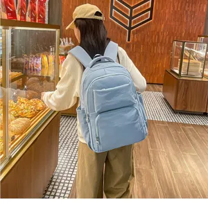 Detailed view of a light blue casual backpack with large capacity, multiple pockets for daily.