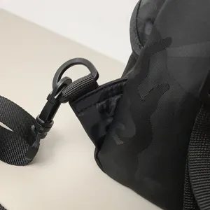 Detail shot of black outdoor crossbody bag with camouflage pattern and durable strap