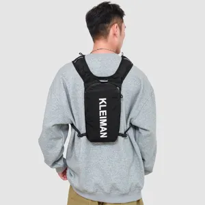 Back view of a lightweight black marathon running vest pack worn over a gray sweater