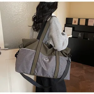 Grand sac de voyage de sport avec motif à carreaux et bandoulière robuste pour le fitness.