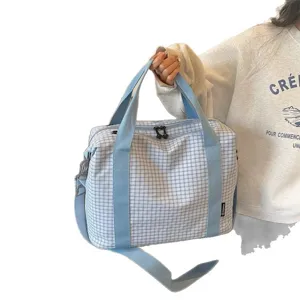 Bolso de viaje de cuadros azul claro con asas dobles y correa para viajes ligeros.