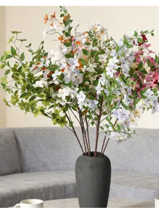 Elegant white and orange artificial osmanthus branches in a minimalist grey ceramic vase