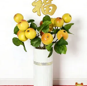 Detailed view of artificial yellow apple branch in a white ceramic vase for New Year decor