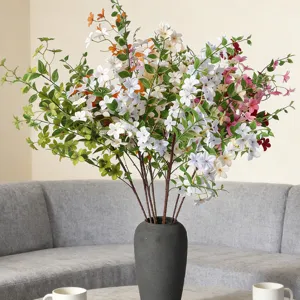 Realistic artificial jasmine osmanthus bouquet in a decorative dark vase for home decor