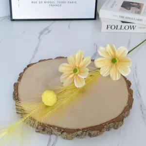 Detailed shot of yellow artificial cosmos flowers on wood slice for stylish home interior decor.